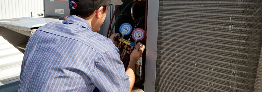 HVAC technician servicing a condenser unit in LaGrange