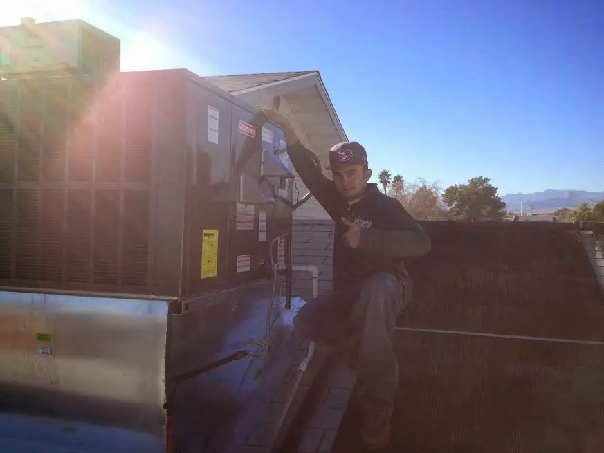 HVAC technician performing Heat Pump Repair on a rooftop unit in LaGrange